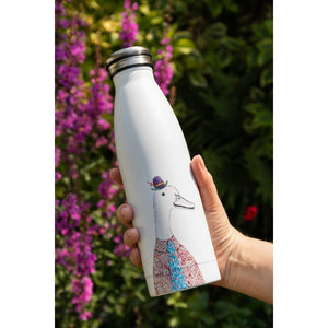 White water bottle with a design of a dog wearing a hat and dress, held in front of purple flowers.